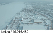 Aerial view of the city residential buildings and a river in winter, urban winter landscape. Стоковое фото, фотограф David Kashakhi / Фотобанк Лори