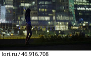 Girl with ponytails walks on background of panorama of modern night city. Стоковое фото, фотограф David Kashakhi / Фотобанк Лори