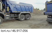 Serbia, Belgrade - July 30, 2021: Dump trucks replacing each other. Редакционное фото, фотограф David Kashakhi / Фотобанк Лори