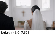Action.A view of the people from behind who decided to get married in a church. Стоковое фото, фотограф David Kashakhi / Фотобанк Лори