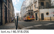 Portugal, Lisbon - July 17, 2022: Trams passing through narrow streets of European city. Редакционное фото, фотограф David Kashakhi / Фотобанк Лори