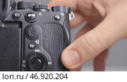 Close-up photographer inserts new memory card into camera. Редакционное фото, фотограф David Kashakhi / Фотобанк Лори