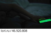 Sleepy guy waking up after hearing alarm clock signal on smartphone, reaching for ringing mobile phone with chromakey and using it. Стоковое фото, фотограф David Kashakhi / Фотобанк Лори