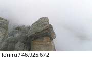 Top view of rock plunging into cold autumn fog. Стоковое фото, фотограф David Kashakhi / Фотобанк Лори