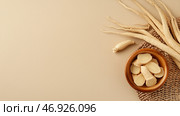 Fresh slices of ginseng root displayed in a bowl alongside whole roots on a neutral background. Стоковое AI-изображение, AI-художник Сергей Толмачёв / Фотобанк Лори