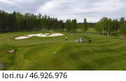 Golfers hitting golf shot with club on course while on summer vacation, aerial. Стоковое фото, фотограф David Kashakhi / Фотобанк Лори