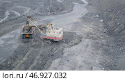 Excavator falls asleep rubble in dumper on outdoor quarry in extraction of minerals. Стоковое фото, фотограф David Kashakhi / Фотобанк Лори
