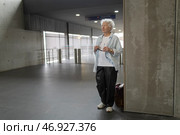 Elderly woman waiting in modern building concourse with travel bag. Стоковое фото, фотограф Константин Шишкин / Фотобанк Лори