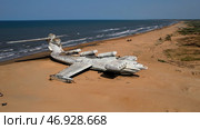 Aerial view of a ruined abandoned airplane found in an uninhabited island near the sea on blue sky background. Стоковое фото, фотограф David Kashakhi / Фотобанк Лори