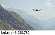 Aerial view of a quadcopter flying above green mountains on morning haze background. Стоковое фото, фотограф David Kashakhi / Фотобанк Лори