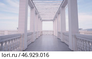 Walking among white marble pillars creating a beautiful corridor on blue sky background. Стоковое фото, фотограф David Kashakhi / Фотобанк Лори