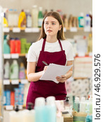 Girl seller with paper report, plans to replenish restock stores inventory. Стоковое фото, фотограф Яков Филимонов / Фотобанк Лори