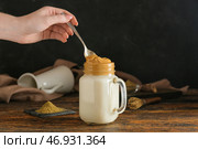 Женщина помешивает вкусный далгона ходжича латте за столом. Стоковое фото, фотограф Pixel_shot / Фотобанк Лори
