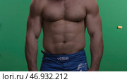 Muscular man standing on green screen. Стоковое фото, фотограф David Kashakhi / Фотобанк Лори