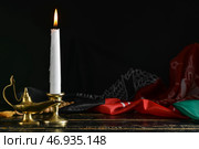 Горящая свеча, лампа и флаг Афганистана на столе на темном фоне. Стоковое фото, фотограф Pixel_shot / Фотобанк Лори