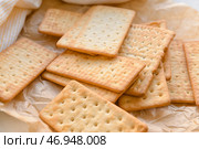 Вкусные крекеры на пергаментной бумаге, крупным планом. Стоковое фото, фотограф Pixel_shot / Фотобанк Лори