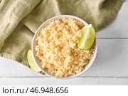 Чаша с вкусным кус-кусом и лаймом на светлом деревянном фоне. Стоковое фото, фотограф Pixel_shot / Фотобанк Лори