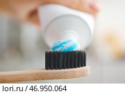 Выдавливание пасты на зубную щетку на размытом фоне, крупным планом. Стоковое фото, фотограф Pixel_shot / Фотобанк Лори