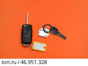 Различные ключи с брелоком и пластиковой биркой на оранжевом фоне. Стоковое фото, фотограф Pixel_shot / Фотобанк Лори