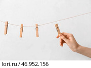 Женщина вешает прищепки на светлом фоне. Стоковое фото, фотограф Pixel_shot / Фотобанк Лори