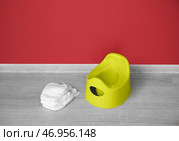 Горшок и подгузники на сером деревянном полу возле цветной стены. Стоковое фото, фотограф Pixel_shot / Фотобанк Лори