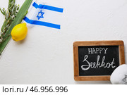 Доска с текстом HAPPY SUKKOT, флагом Израиля и символикой фестиваля на светлом фоне. Стоковое фото, фотограф Pixel_shot / Фотобанк Лори