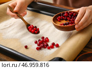 Женщина готовит вкусную засахаренную клюкву на деревянном фоне, крупным планом. Стоковое фото, фотограф Pixel_shot / Фотобанк Лори