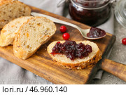 Деревянная доска вкусных тостов с брусничным джемом на сером фоне, крупным планом. Стоковое фото, фотограф Pixel_shot / Фотобанк Лори
