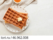 Тарелка с вкусными бельгийскими вафлями и маслом на светлом фоне. Стоковое фото, фотограф Pixel_shot / Фотобанк Лори