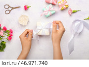 Женщина упаковывает подарочную коробку и красивые розы на белом фоне. Стоковое фото, фотограф Pixel_shot / Фотобанк Лори