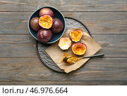 Тарелка и миска с вкусными маракуйями на деревянном фоне. Стоковое фото, фотограф Pixel_shot / Фотобанк Лори