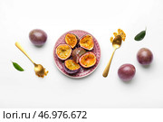 Тарелка с вкусными нарезанными маракуйями на белом фоне. Стоковое фото, фотограф Pixel_shot / Фотобанк Лори
