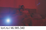 Young couple watching a movie at home using a projector. Стоковое видео, видеограф Константин Шишкин / Фотобанк Лори