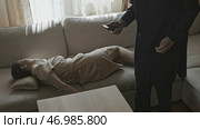 Woman is lying on couch like she was murdered and someone is taking her phone. Стоковое фото, фотограф David Kashakhi / Фотобанк Лори