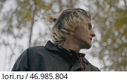 Young man walks in woods with phone and looks around anxiously. Стоковое фото, фотограф David Kashakhi / Фотобанк Лори