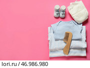 Детская одежда, подгузники и деревянный гребень для волос на розовом фоне. Стоковое фото, фотограф Pixel_shot / Фотобанк Лори
