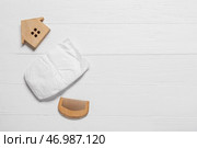 Детские подгузники, расческа и игрушечный домик на белом деревянном фоне. Стоковое фото, фотограф Pixel_shot / Фотобанк Лори
