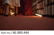 Elegant women mysteriously gather in night library with flashing light. Стоковое фото, фотограф David Kashakhi / Фотобанк Лори