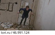 Amateur video shot of man trying to survive in damaged brick house. Стоковое фото, фотограф David Kashakhi / Фотобанк Лори