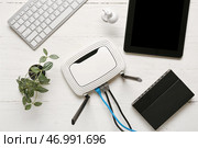 Современный Wi-Fi маршрутизатор с клавиатурой и планшетным компьютером на белом деревянном фоне. Стоковое фото, фотограф Pixel_shot / Фотобанк Лори