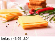 Кусочки вкусного обработанного сыра с луком-пореем и чили на розовом фоне плитки. Стоковое фото, фотограф Pixel_shot / Фотобанк Лори