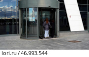 Two female friends entering modern shopping center or office building. Стоковое фото, фотограф David Kashakhi / Фотобанк Лори