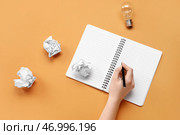 Женщина пишет в блокноте на оранжевом фоне. Концепция логики. Стоковое фото, фотограф Pixel_shot / Фотобанк Лори