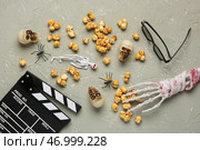 Карамельный попкорн, киношный хлопушка и хэллоуинский декор на сером гранжевом фоне. Стоковое фото, фотограф Pixel_shot / Фотобанк Лори