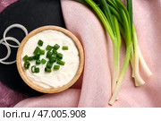 Миска вкусной сметаны с нарезанным луком-пореем и луком на розовом фоне. Стоковое фото, фотограф Pixel_shot / Фотобанк Лори