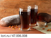 Стаканы вкусного кваса, хлеб, изюм и пшеничные зерна на деревянном фоне. Стоковое фото, фотограф Pixel_shot / Фотобанк Лори