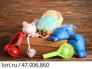 Коробка ненужных вещей для распродажи на фоне коричневой деревянной поверхности. Стоковое фото, фотограф Pixel_shot / Фотобанк Лори