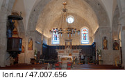 Empty rows of sits, chandelier with candles and stained glass windows. Стоковое фото, фотограф David Kashakhi / Фотобанк Лори