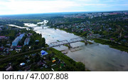 Arial view of a small town crossed by a river with a bridge. Стоковое фото, фотограф David Kashakhi / Фотобанк Лори