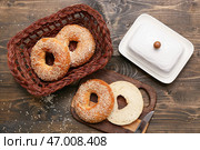 Доска для нарезки и плетёная корзина с вкусными бубликами с кунжутом на деревянном фоне. Стоковое фото, фотограф Pixel_shot / Фотобанк Лори